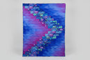 Colorful quilt with a geometric pattern displayed on a stand.