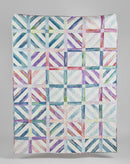 Colorful geometric quilt with a pattern of intersecting lines on a gray background